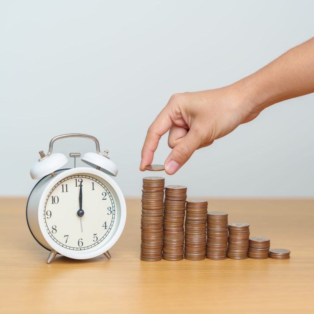 Old time alarm clock with stacks of pennies to illustrate compound interest principles.