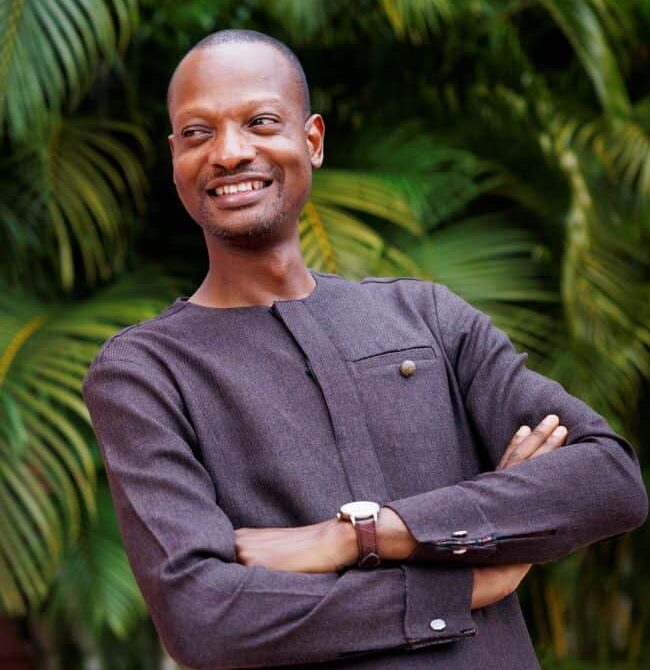 Ghana student posing for a picture in front of a palm tree