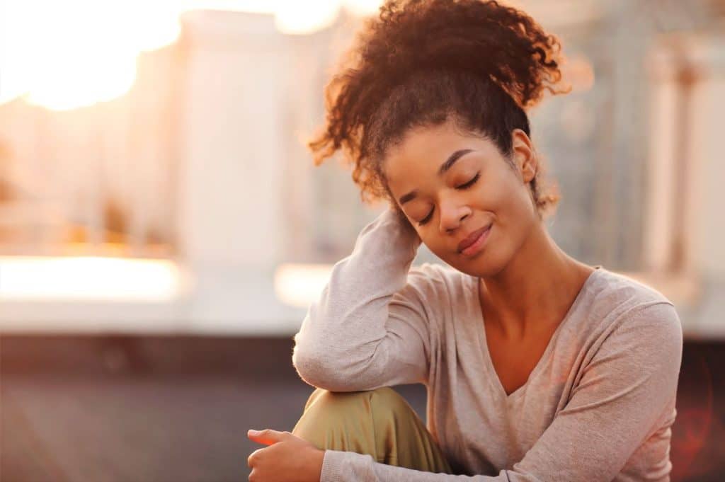 young happy african american girl sitting on roof