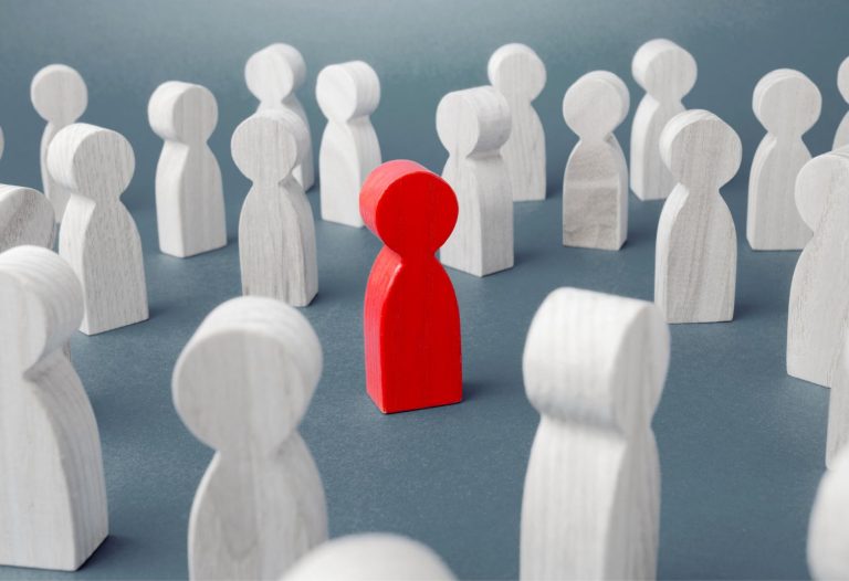 Dare to be different Red figurine of a man in a crowd of people